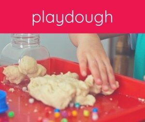 child's hand with playdough