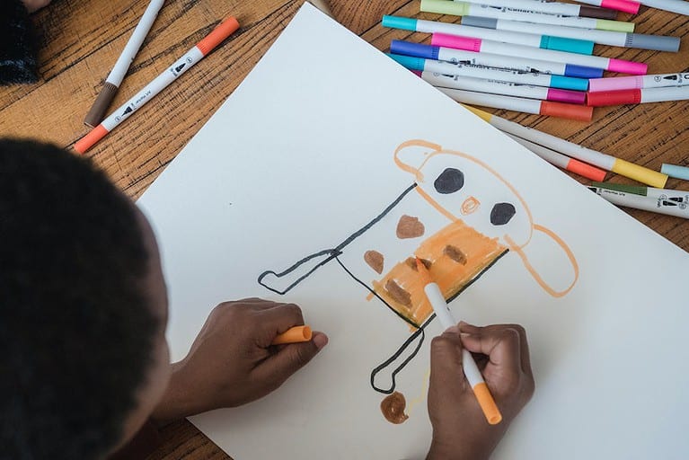 Child draws with markers during a process art activity.
