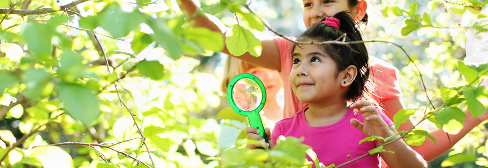 Preschool girl exploring nature using Kaplan's Play Science Starter Kit 