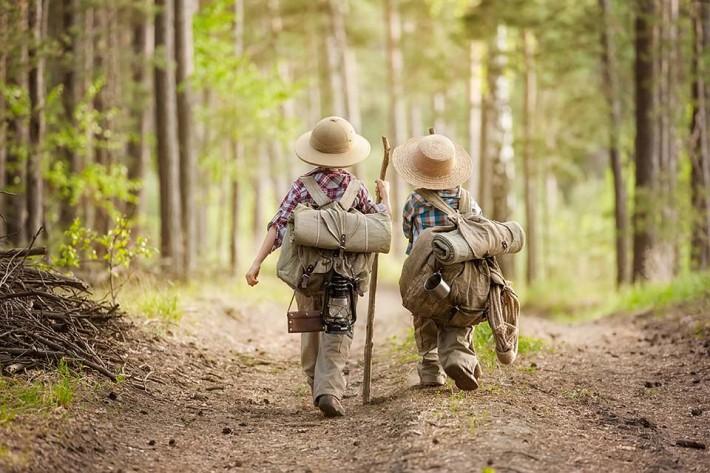Two people in military uniforms walking on a dirt path in the woods

Description automatically generated with low confidence