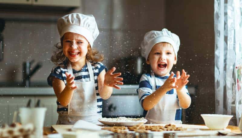 funny kids are preparing the dough, bake cookies in the kitchen
