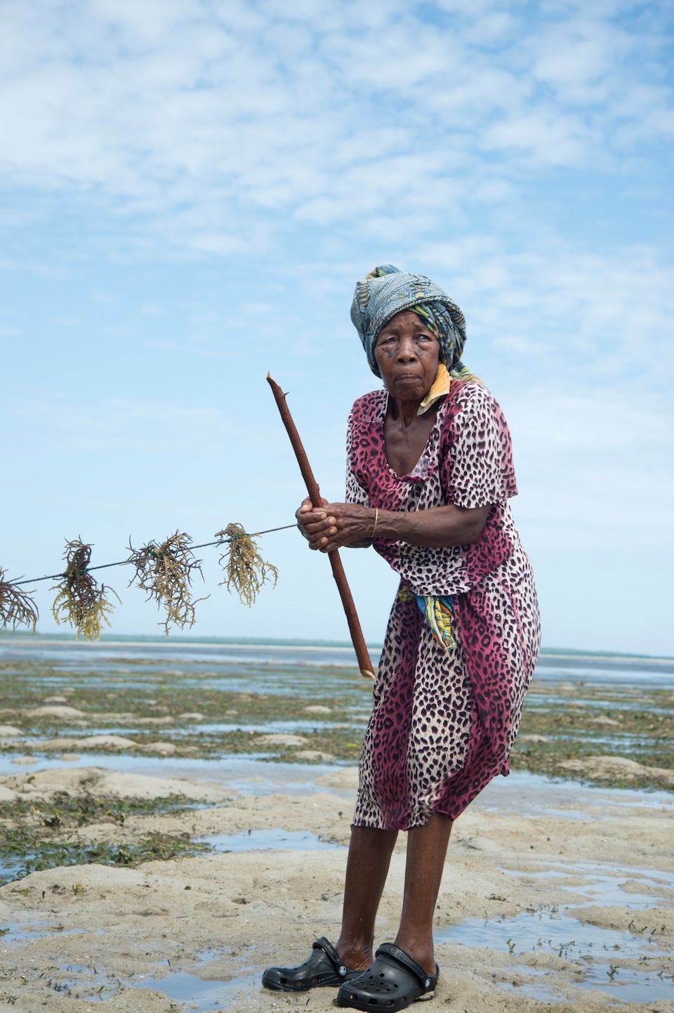 Pernise, a seaweed farmer, with a string of seaweed that she will leave to grow.
