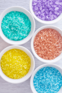 bowls of colorful dyed salt to use in a playing with ice activity for toddlers