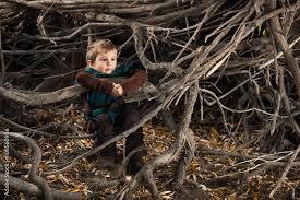 A child sitting in a pile of sticks

Description automatically generated with low confidence