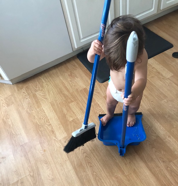 Activities for infants and toddlers helping sweep the kitchen