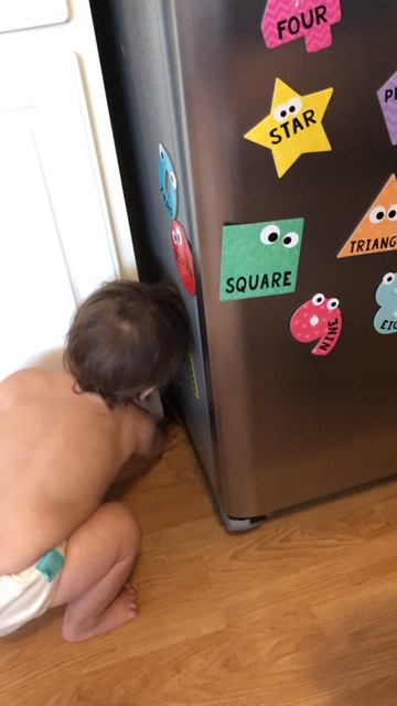 Activities for infants and toddlers playing with shape and number magnets on the refrigerator 